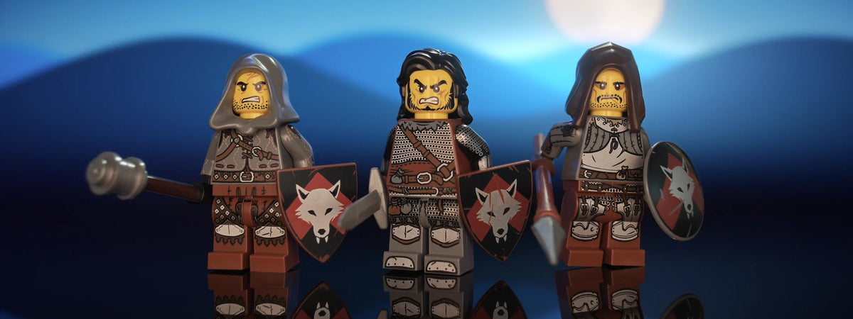 Hero shot of three of Castle Clad Bricks custom pad printed bandit minifigures with accessories, set 1 of 4 — armored figures with shields, night scene, panorama